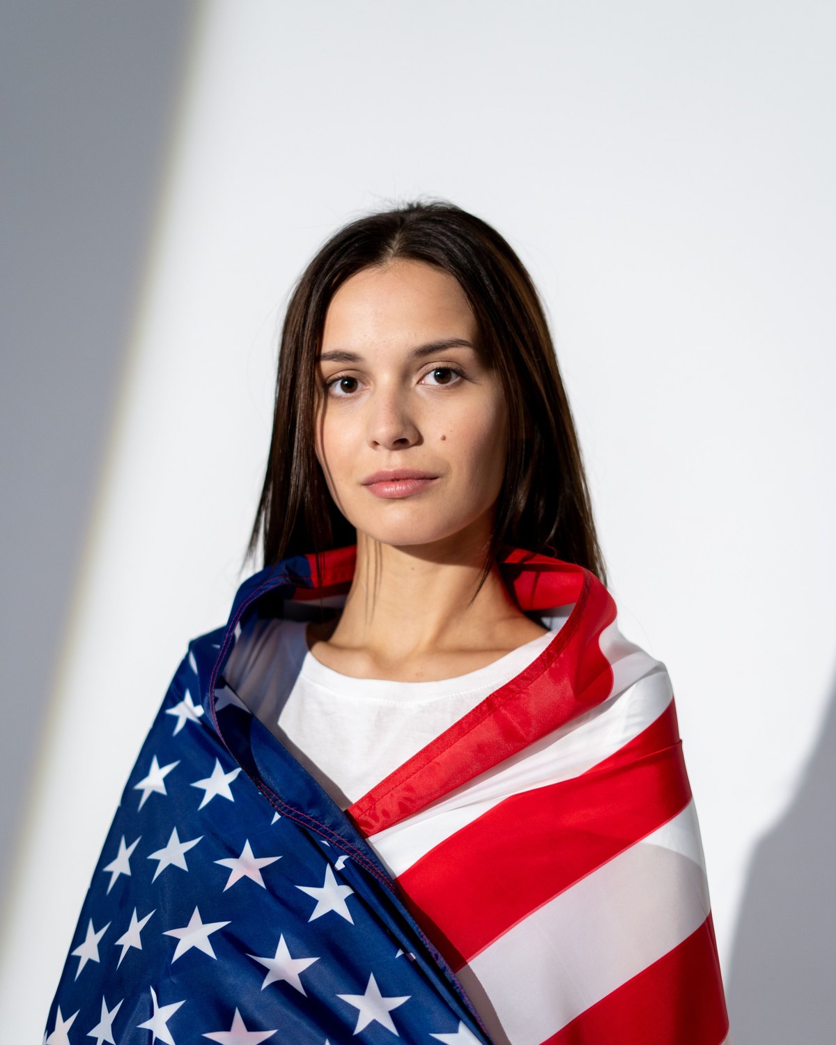 An American flag held around the shoulders, stripes and stitching visible