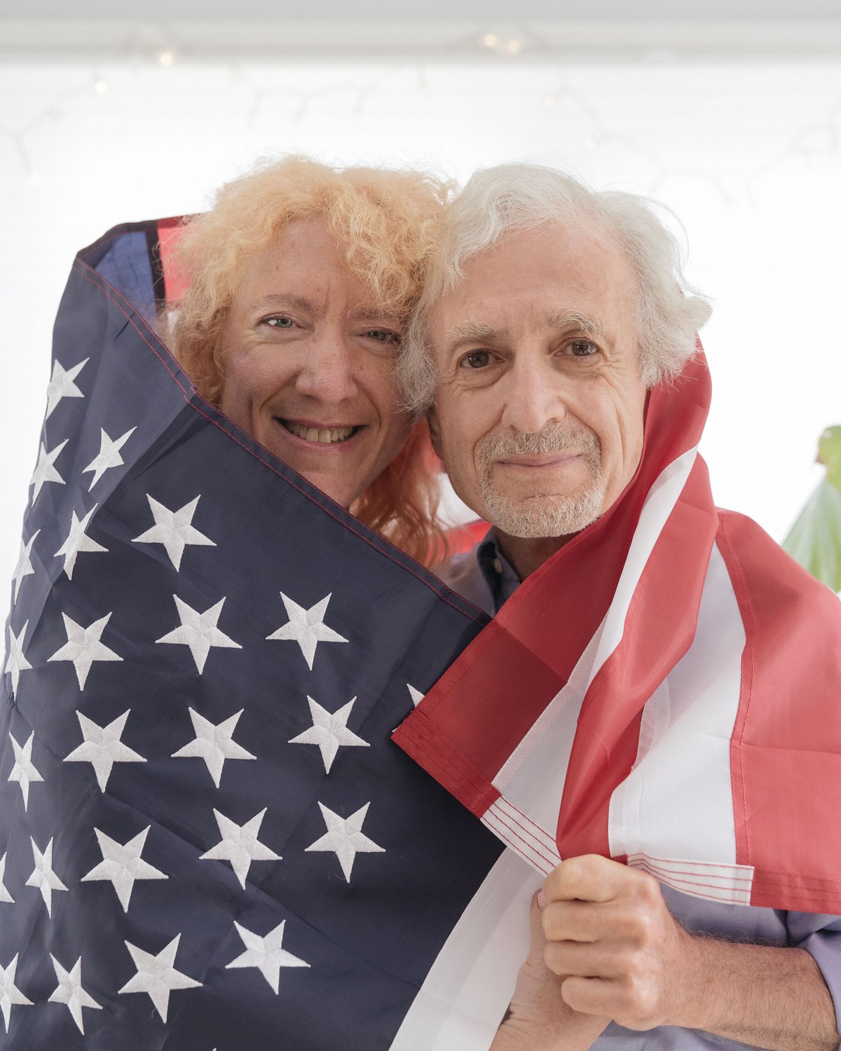 An American flag sewn by Eder Flag, held by a couple outdoors